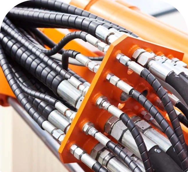 Hydraulslangar i orange kopplingsblock, nästan kvadratisk beskärning