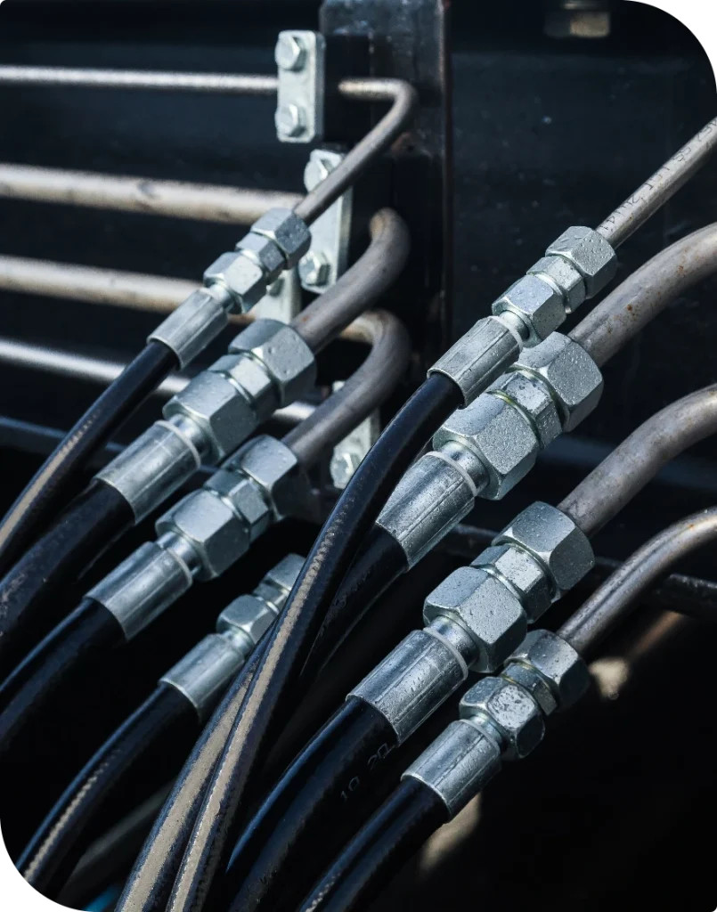 Hydraulslangar med pressade kopplingar uppradade mot mörk bakgrund
